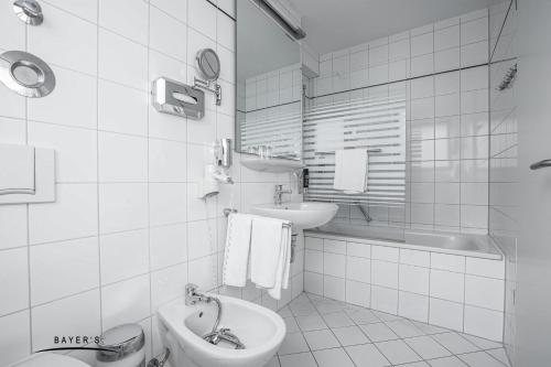 e bagno con lavandino, servizi igienici e vasca. di Bayer's Boardinghouse und Hotel a Monaco