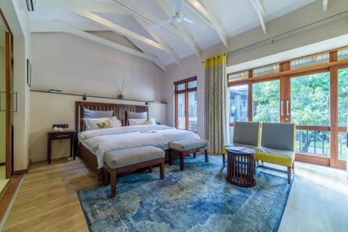 a bedroom with a large bed and a large window at Casterbridge Hollow Boutique Hotel in White River