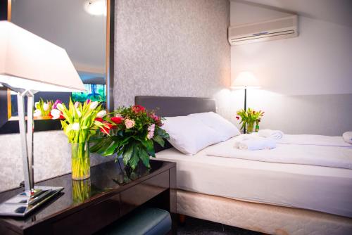 a hotel room with a bed and a table with flowers at Bölsche Hotel in Berlin