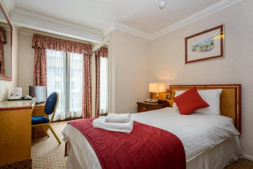 a hotel room with a bed with a red blanket at Russell Hotel in Weymouth