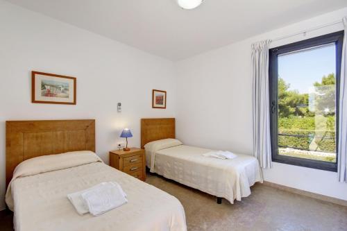 ビニベカにあるVilla Binizahira by Mauter Villasのベッドルーム1室(ベッド2台、窓付)