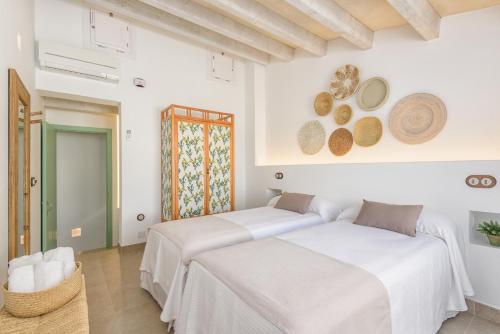 two beds in a room with white walls at Holiday Home Casa Sa Font by Mauter Villas in Ciutadella