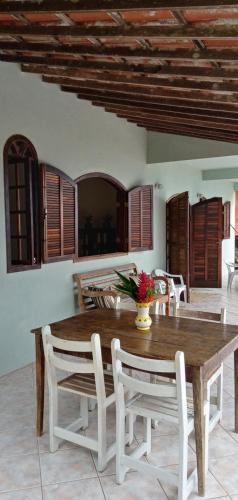 Casa Ilha Grande في برايا دي أراكاتيبا: غرفة طعام مع طاولة وكراسي خشبية