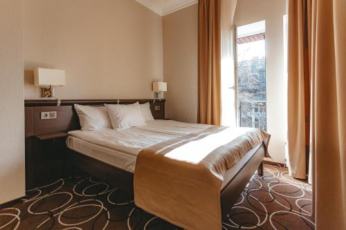 Un pat sau paturi într-o cameră la Apriori Hotel
