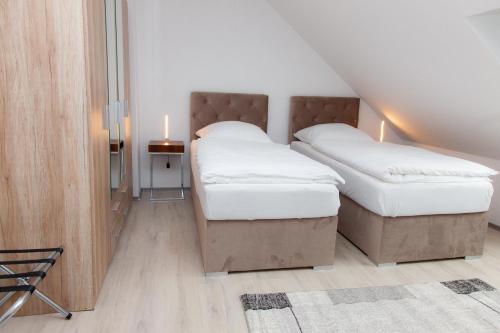 two twin beds in a room with a staircase at T&K Apartments near Messe Fair Trade Düsseldorf und Airport 3B in Duisburg