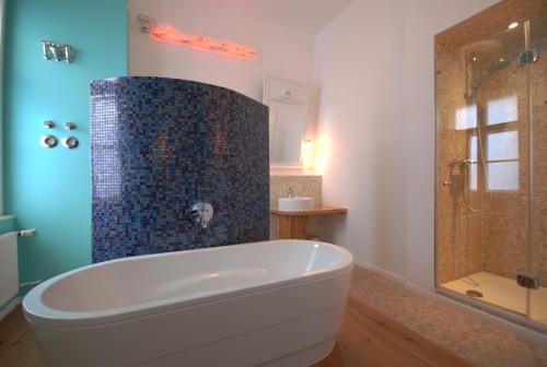 Das Bad ist mit einer Badewanne und einer Dusche ausgestattet. in der Unterkunft Arte Luise Kunsthotel in Berlin
