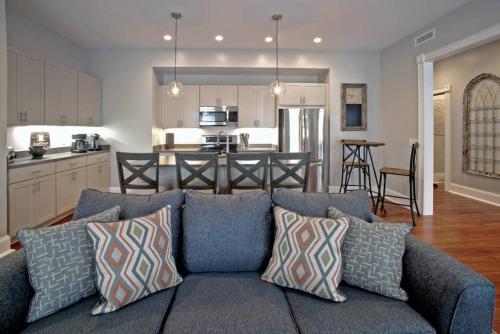 a living room with a blue couch and a kitchen at Newly Renovated 4 bed 3 bath and 2 Parking Spots in Savannah