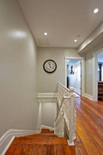 a staircase in a home with a clock on the wall at Newly Renovated 4 bed 3 bath and 2 Parking Spots in Savannah