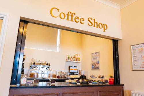 a coffee shop with a sign above a counter at Russell Hotel in Weymouth