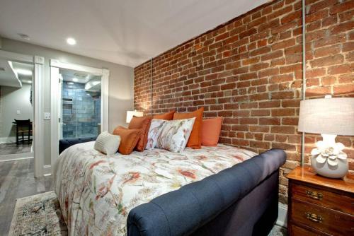 a bedroom with a brick wall and a bed at Restored Historic Home 5 bedroom 4 and a Half Bath in Savannah
