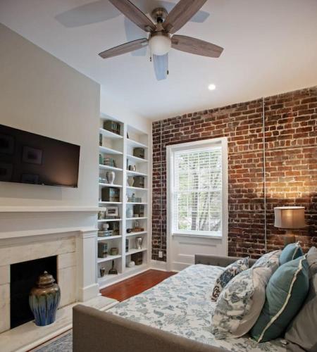 a living room with a fireplace and a ceiling fan at Restored Historic Home 5 bedroom 4 and a Half Bath in Savannah