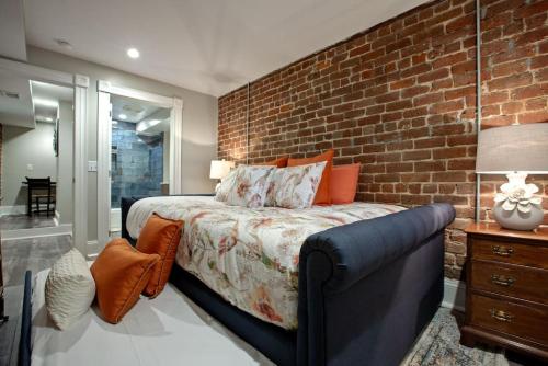 a bedroom with a brick wall and a bed and a couch at Restored Historic Home 5 bedroom 4 and a Half Bath in Savannah