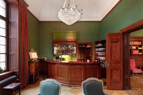 a bar in a green room with a chandelier at Lejondals Slott in Bro