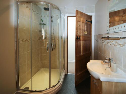 Cwm Derw Cottage في Llanafan-fawr: حمام مع دش ومغسلة