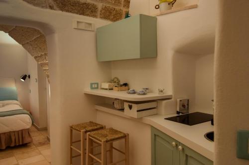 a kitchen with a sink and a counter with two stools at Leavì in Polignano a Mare
