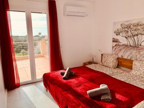 a bedroom with a red bed and a balcony at CASA Luz Solar - schöne Finca in Strandnähe, Privatpool, Klimaanlage, Wifi in Cala Santanyi