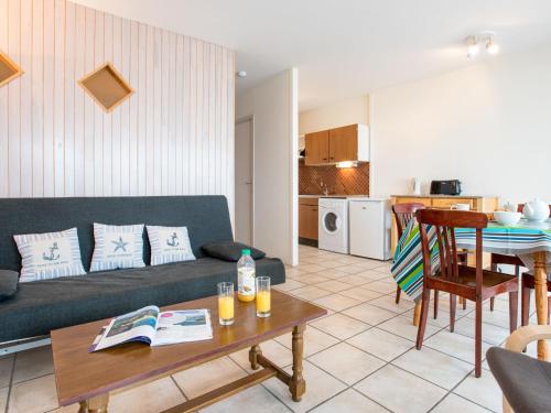 een woonkamer met een bank en een tafel bij Apartment Port Maria-1 by Interhome in Quiberon