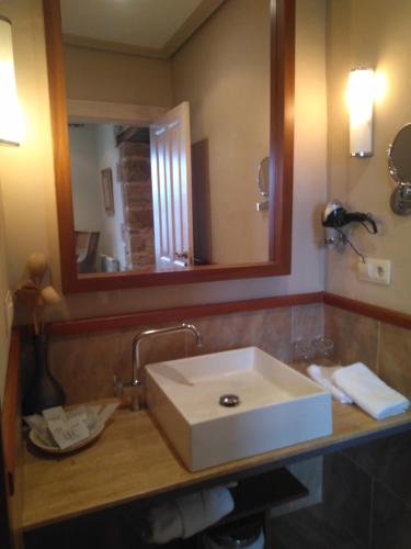 a bathroom with a white sink and a mirror at Narbasu Restaurante y Hotel in Cereceda