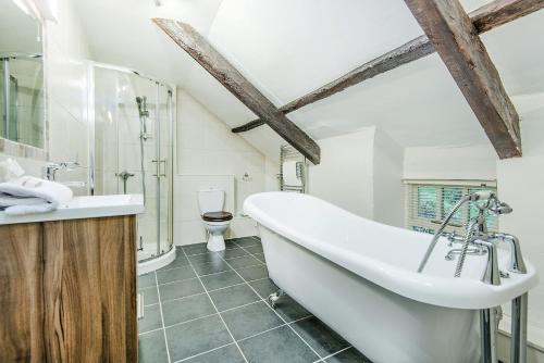 a bathroom with a large tub and a toilet at Clydey Cottages Pembrokeshire in Pembrokeshire