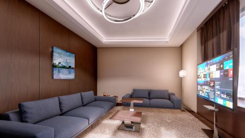 a living room with a couch and a flat screen tv at Hotel Bulgaria in Burgas City