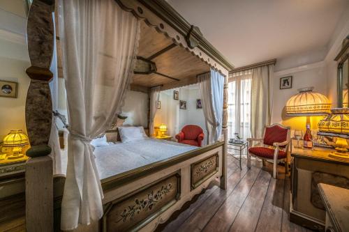 a bedroom with a canopy bed and a desk at Corvin Hotel Budapest Sissi Wing in Budapest