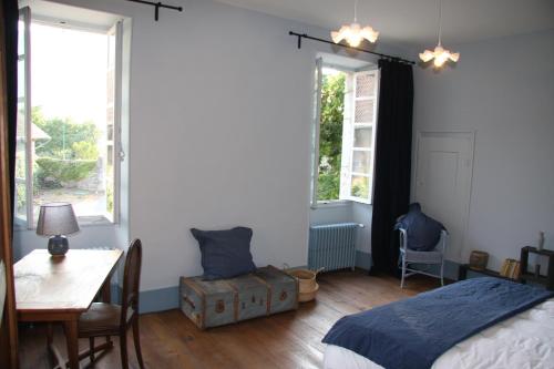 a bedroom with a bed and a table and windows at Château La Violette in Les Marches