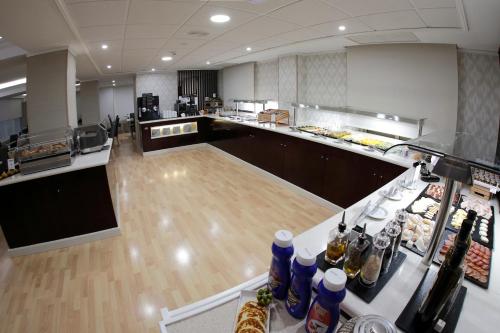 an empty restaurant with a counter with food at Sercotel Carlos III in Cartagena