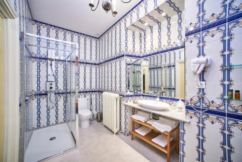 y baño con paredes de azulejos azules y blancos. en CHATEAU DE LA RICHERIE, en Beaurepaire