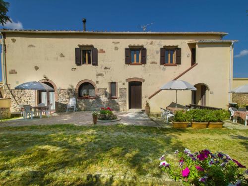 a house with a yard with chairs and umbrellas at Apartment Il Secondo-1 by Interhome in Bibbona