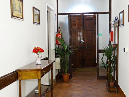 a hallway with a door and a table and flowers at Affittacamere Arancio in Lucca