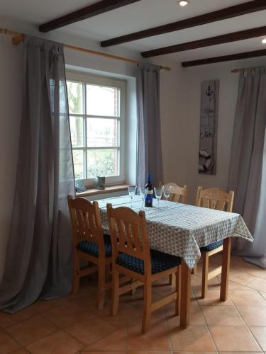 een eetkamer met een tafel en stoelen en een raam bij Strandläufer in Reitland