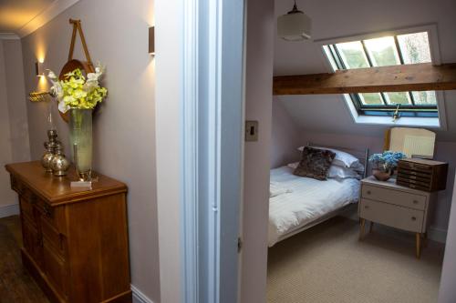a small attic bedroom with a bed and a window at Haweswater Hotel in Bampton