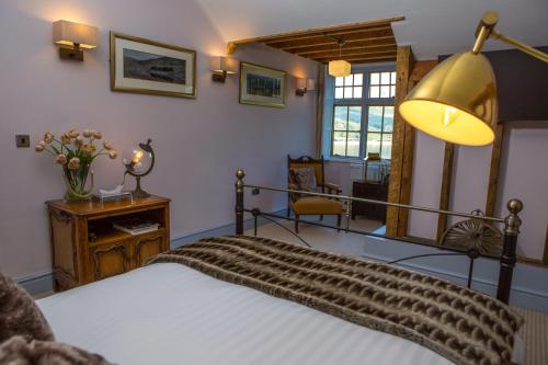 a bedroom with a bed and a table and a lamp at Haweswater Hotel in Bampton