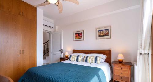 a bedroom with a large bed with a blue blanket at 4 bedroom Villa Helidoni with private infinity pool, Aphrodite Hills Resort in Kouklia