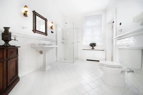 biała łazienka z toaletą i umywalką w obiekcie Apartamenty Carskie w Białowieży
