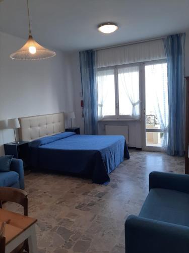 a bedroom with a blue bed and a couch at Residence Sole in Albenga
