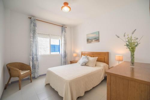 1 dormitorio con cama, escritorio y ventana en Apartamento Almadraba, en Chiclana de la Frontera