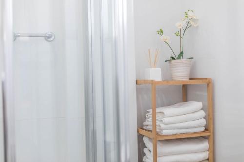 a bathroom with a shelf with towels and a shower at Apartamento Almadraba in Chiclana de la Frontera