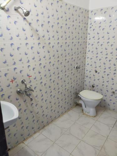 a bathroom with a toilet and a sink at HOTEL BUDDHA in Kushinagar