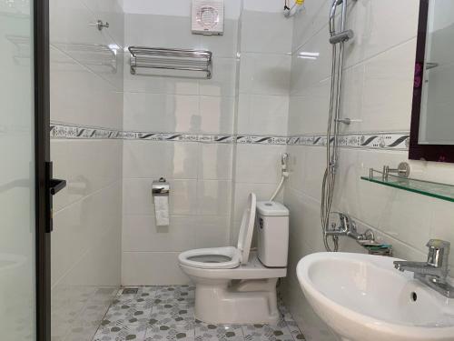 een witte badkamer met een toilet en een wastafel bij Sen's Homestay in Ninh Binh