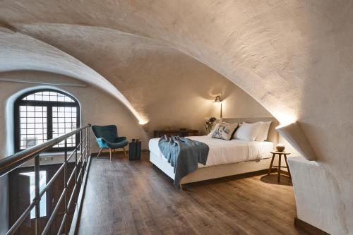 a bedroom with a bed and a staircase in a room at Winery Hotel 1870 in Fira