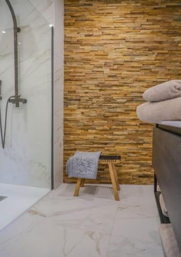 La salle de bains est pourvue d'une douche et d'un banc à côté d'un mur. dans l'établissement Casa Dalessio 3 - Villa Vue Mer et Piscine, à Brando