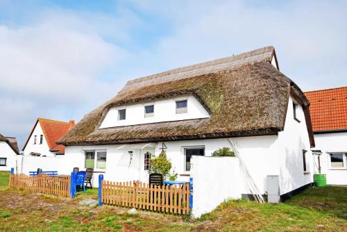 a white house with a thatched roof at Ferienzimmer unterm Reetdach in Pl in Neuendorf