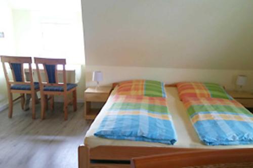 Een bed of bedden in een kamer bij Ferienzimmer unterm Reetdach in Pl