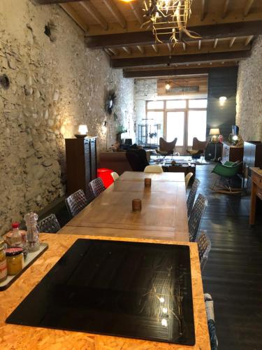 a large wooden table in a room with a couch at le 25bis in Saint-Martory