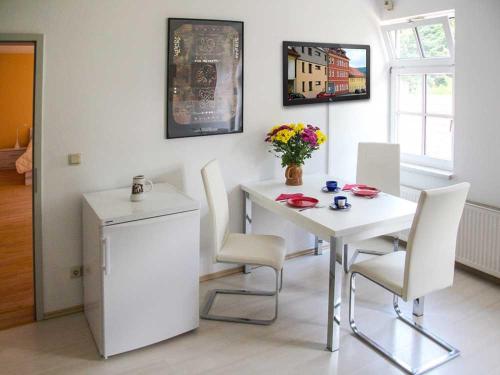 a dining room with a white table and chairs at Ferienwohnung Bernhardt in Zella-Mehlis