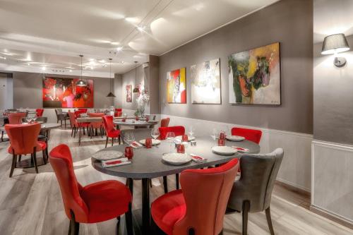 a dining room with tables and red chairs at Boutique-Hôtel Restaurant L'Atelier d'Epicure Logis in Castels