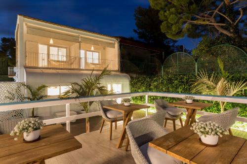 a patio with tables and chairs and a building at Antonio's House in Sitges