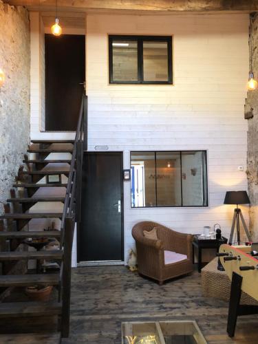 a living room with a staircase leading up to a house at le 25bis in Saint-Martory