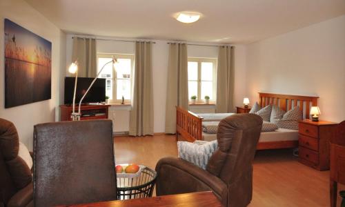 un salon avec un lit, un canapé et des chaises dans l'établissement Zum Augustiner I, Erfurt Zentrum, à Erfurt